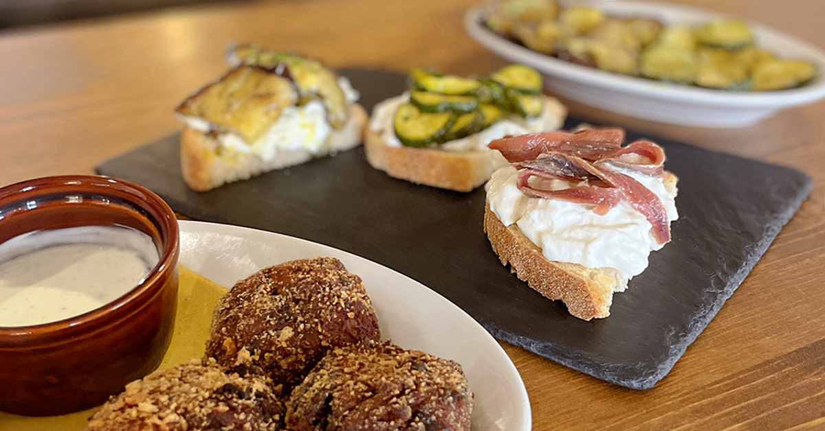 Three dishes from the new summer menu, crostini, meatballs and aubergines